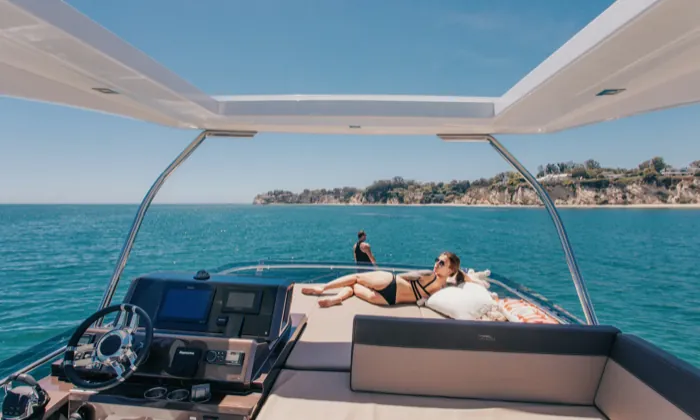 Guests sunbathing on the foredeck as Andiamo lies off a headland