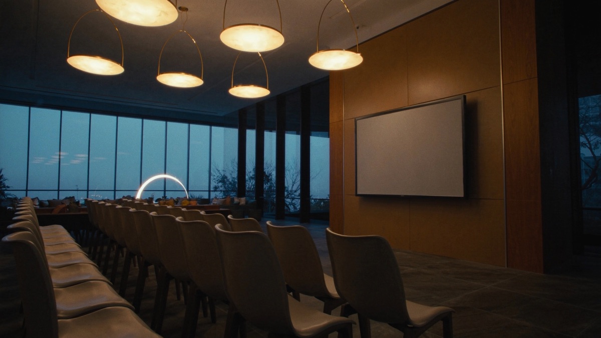 Modern training room with rows of chairs facing a presentation screen at dusk