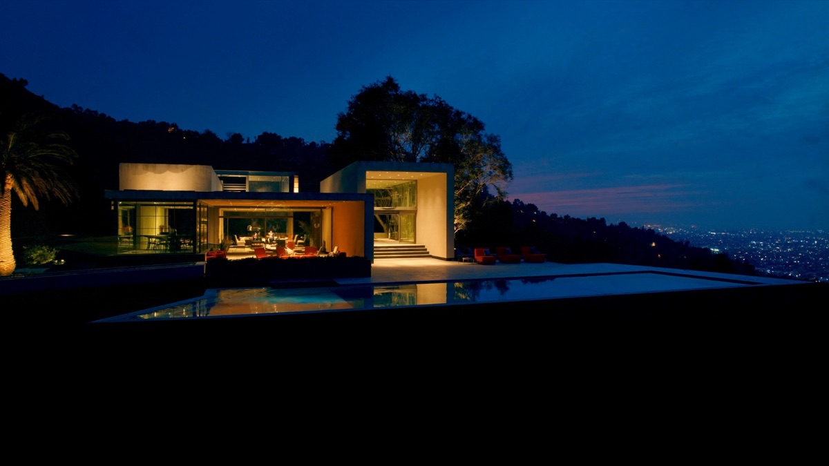 Modern Hollywood Hills home glowing at twilight above the city lights